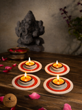 Set of 4 hand-painted terracotta plate diyas lit for Diwali puja